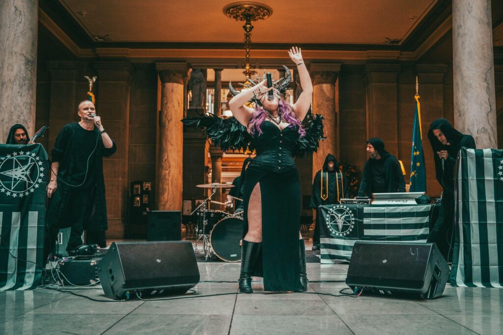 Members of the Satanic Temple Indianapolis dressed in black singing at a service.